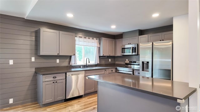 22470 Sunridge Way NE, Poulsbo, WA 98370 - kitchen with stainless steel appliances, a sink, dark countertops, gray cabinets, and light wood finished floors