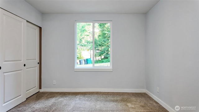 22470 Sunridge Way NE, Poulsbo, WA 98370 - unfurnished bedroom featuring carpet floors, multiple windows, and baseboards