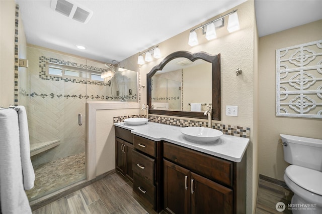 1901 Sleepy Hollow Rd, Wenatchee, WA 98801 - full bath featuring double vanity, a stall shower, wood finished floors, decorative backsplash, and toilet