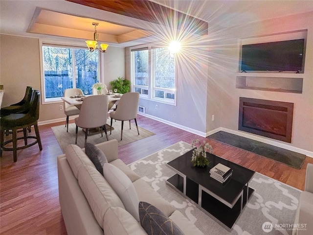 18528 20th Dr SE, Bothell, WA 98012 - living area featuring baseboards, a tray ceiling, plenty of natural light, and a glass covered fireplace