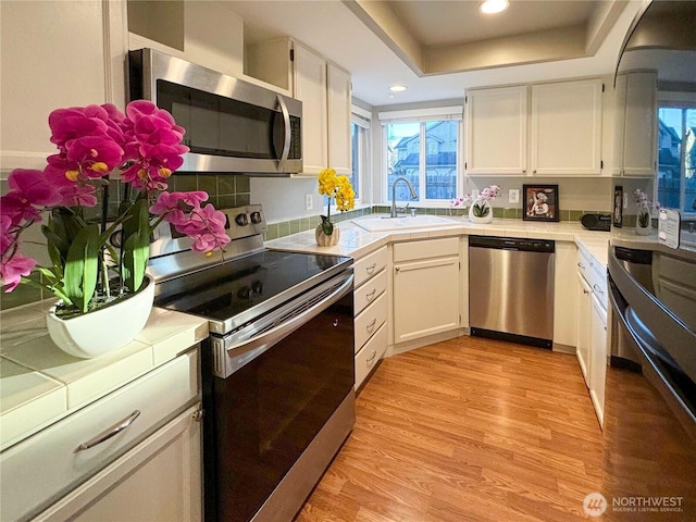 18528 20th Dr SE, Bothell, WA 98012 - kitchen with appliances with stainless steel finishes, a sink, tile countertops, white cabinetry, and light wood finished floors