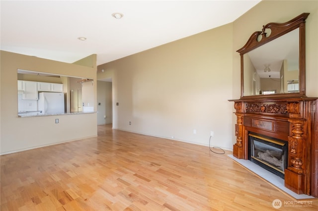 5419 N Court St, Ruston, WA 98407 - unfurnished living room with a fireplace with flush hearth, light wood-style flooring, and baseboards