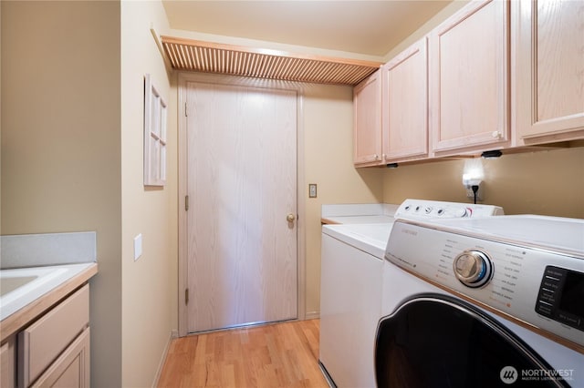 5419 N Court St, Ruston, WA 98407 - laundry area featuring washing machine and clothes dryer, light wood-type flooring, cabinet space, and baseboards