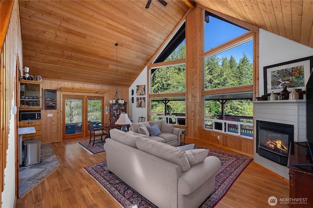51 E Glamis Ct, Shelton, WA 98584 - living area featuring high vaulted ceiling, wooden walls, wooden ceiling with exposed beams, wood finished floors, and a glass covered fireplace