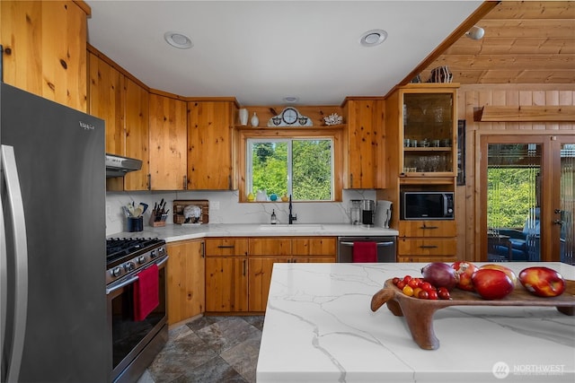 51 E Glamis Ct, Shelton, WA 98584 - kitchen featuring a sink, appliances with stainless steel finishes, under cabinet range hood, tasteful backsplash, and brown cabinetry
