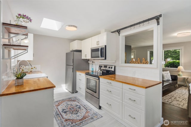 19027 37th Ave S, Seatac, WA 98188 - kitchen featuring butcher block countertops, stainless steel appliances, a sink, a skylight, and decorative backsplash