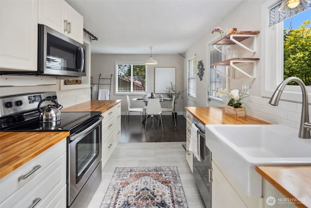 19027 37th Ave S, Seatac, WA 98188 - kitchen featuring butcher block countertops, stainless steel appliances, a sink, decorative backsplash, and white cabinetry