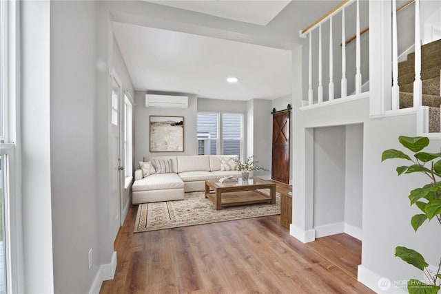 45885 Division St, Concrete, WA 98237 - living area featuring a wall mounted AC, baseboards, a barn door, wood finished floors, and recessed lighting