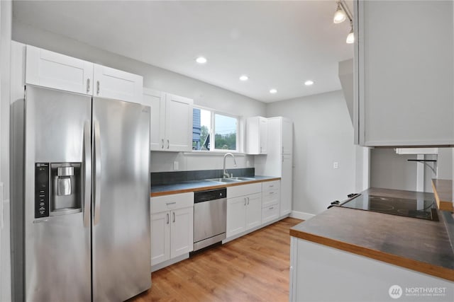 45885 Division St, Concrete, WA 98237 - kitchen featuring stainless steel appliances, a sink, white cabinetry, light wood-style flooring, and recessed lighting