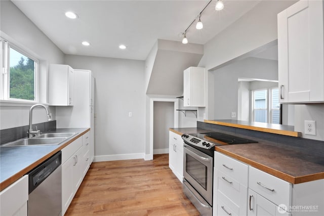 45885 Division St, Concrete, WA 98237 - kitchen with stainless steel appliances, a sink, dark countertops, light wood-type flooring, and white cabinetry