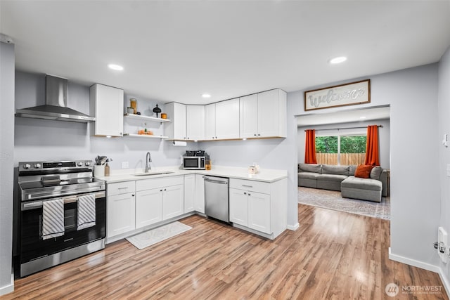 140 Tremont St, Port Orchard, WA 98366 - kitchen with appliances with stainless steel finishes, wall chimney exhaust hood, a sink, light countertops, and recessed lighting