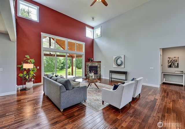 936 W Axton Rd, Bellingham, WA 98226 - living area with a high ceiling, a ceiling fan, a stone fireplace, dark wood-type flooring, and baseboards
