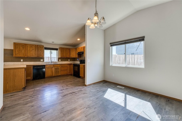 912 Eagle Crest Pl, Port Orchard, WA 98366 - kitchen featuring black appliances, lofted ceiling, a chandelier, brown cabinetry, and under cabinet range hood