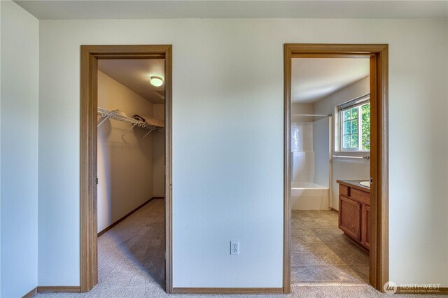 912 Eagle Crest Pl, Port Orchard, WA 98366 - unfurnished bedroom featuring a walk in closet, connected bathroom, and light colored carpet