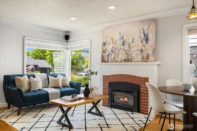 7530 25th Ave NW, Seattle, WA 98117 - living area with light wood finished floors, a textured ceiling, a brick fireplace, crown molding, and recessed lighting