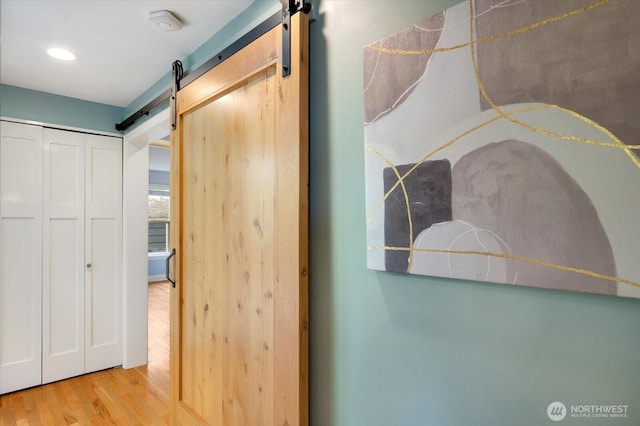 7530 25th Ave NW, Seattle, WA 98117 - corridor featuring a barn door, wood finished floors, and recessed lighting