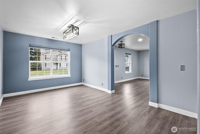 20723 197th Ave E, Orting, WA 98360 - empty room featuring arched walkways, dark wood finished floors, and baseboards