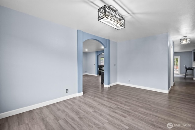 20723 197th Ave E, Orting, WA 98360 - unfurnished dining area featuring arched walkways, wood finished floors, and baseboards