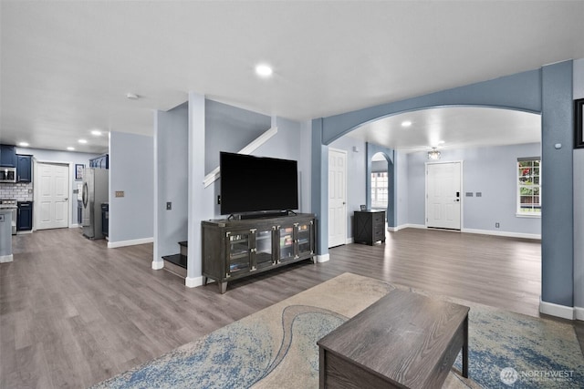 20723 197th Ave E, Orting, WA 98360 - living room with arched walkways, dark wood finished floors, baseboards, stairs, and recessed lighting