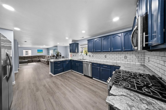 20723 197th Ave E, Orting, WA 98360 - kitchen featuring a sink, blue cabinetry, a peninsula, stainless steel appliances, and open floor plan