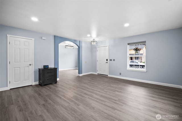 20723 197th Ave E, Orting, WA 98360 - unfurnished living room with arched walkways, recessed lighting, baseboards, and wood finished floors