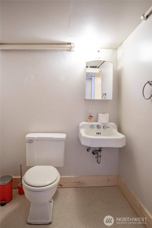813 E 3rd Ave, Ellensburg, WA 98926 - bathroom featuring toilet, baseboards, and a sink