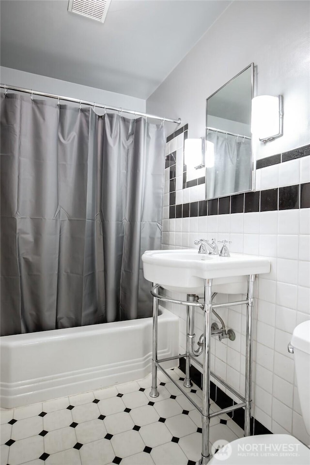 813 E 3rd Ave, Ellensburg, WA 98926 - bathroom featuring tile walls, shower / tub combo, and toilet