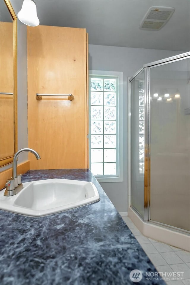 813 E 3rd Ave, Ellensburg, WA 98926 - bathroom with tile patterned floors, a sink, and a shower stall