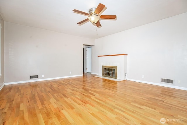 813 E 3rd Ave, Ellensburg, WA 98926 - unfurnished living room featuring light wood finished floors, a ceiling fan, a tile fireplace, and baseboards