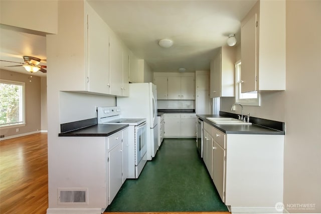 813 E 3rd Ave, Ellensburg, WA 98926 - kitchen with white range with electric cooktop, a sink, dark countertops, dishwasher, and white cabinetry