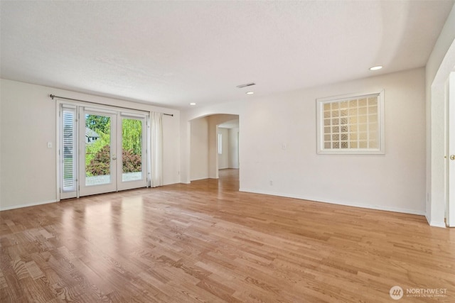 11112 E Riverside Dr, Bothell, WA 98011 - spare room with arched walkways, light wood-type flooring, baseboards, and recessed lighting