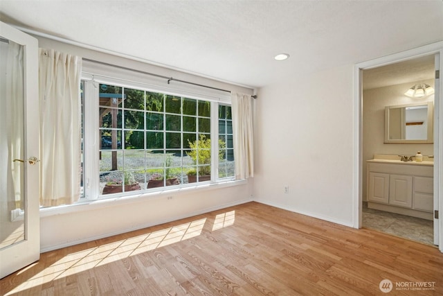 11112 E Riverside Dr, Bothell, WA 98011 - unfurnished bedroom featuring wood finished floors, baseboards, a sink, and connected bathroom