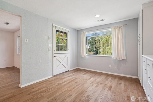 11112 E Riverside Dr, Bothell, WA 98011 - empty room featuring light wood finished floors, baseboards, and a textured wall