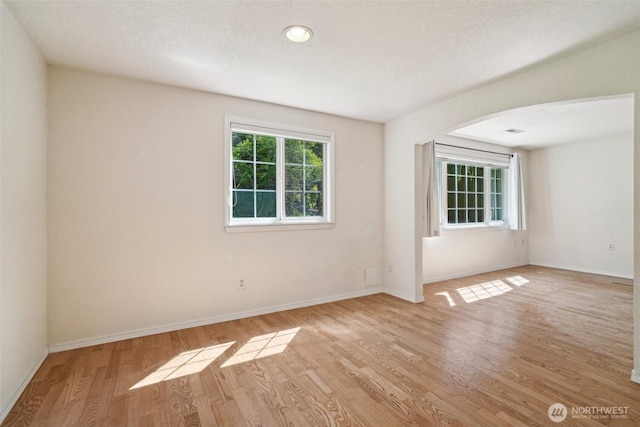 11112 E Riverside Dr, Bothell, WA 98011 - empty room with wood finished floors, baseboards, arched walkways, and recessed lighting