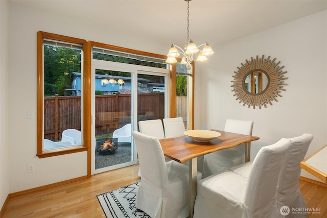 7522 NE 204th Pl, Kenmore, WA 98028 - dining area with a chandelier, light wood-style floors, and baseboards