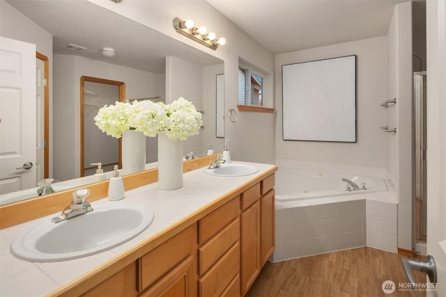 7522 NE 204th Pl, Kenmore, WA 98028 - full bathroom with double vanity, a tub with jets, and wood finished floors