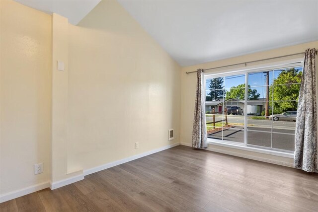 5004 188th St SW, Lynnwood, WA 98037 - spare room with wood finished floors, vaulted ceiling, and baseboards