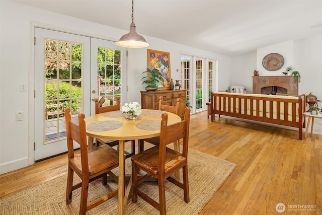 11002 Hyla Ave NE, Bainbridge Island, WA 98110 - dining room featuring light wood-type flooring, french doors, and a fireplace