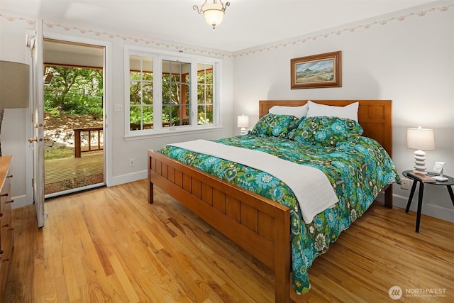 11002 Hyla Ave NE, Bainbridge Island, WA 98110 - bedroom with baseboards, light wood-type flooring, and access to outside