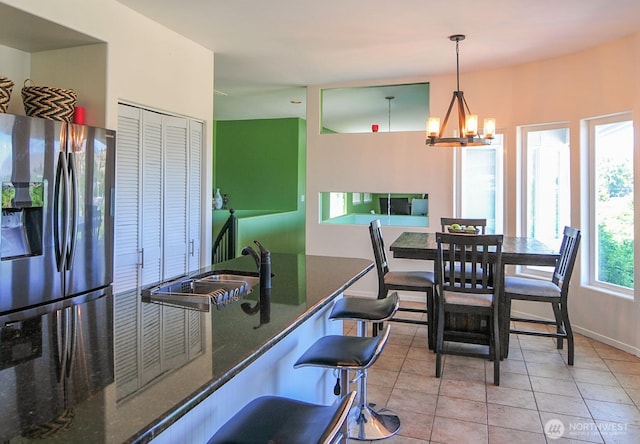301 Canyon Pl, Wenatchee, WA 98801 - kitchen with stainless steel fridge, a sink, a chandelier, light tile patterned floors, and pendant lighting