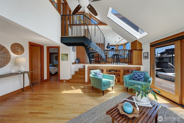 3110 Portage Bay Pl E Unit B, Seattle, WA 98103 - living room featuring stairway, a skylight, light wood finished floors, ceiling fan, and high vaulted ceiling