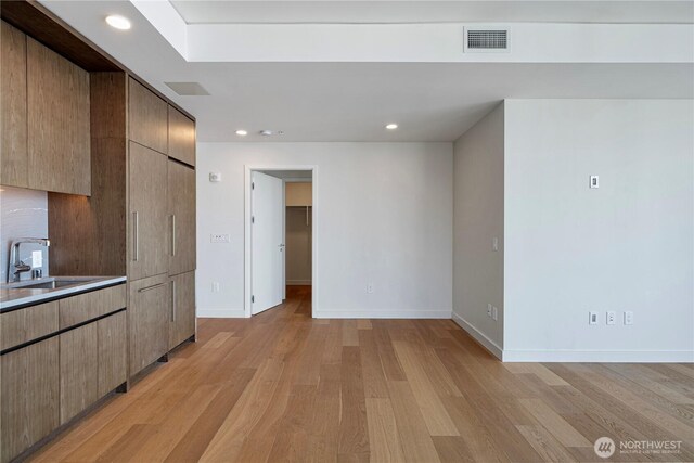121 Stewart St Unit 2507, Seattle, WA 98101 - kitchen featuring a sink, baseboards, light wood-style flooring, recessed lighting, and modern cabinets