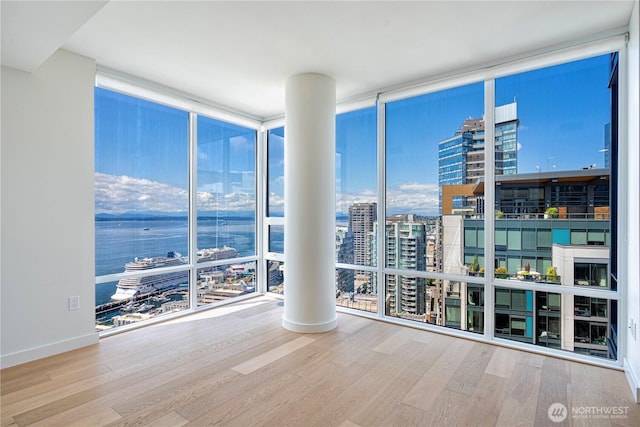 121 Stewart St Unit 2507, Seattle, WA 98101 - empty room with expansive windows, a view of city, wood finished floors, and plenty of natural light
