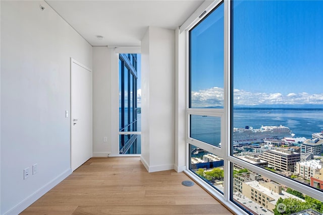 121 Stewart St Unit 2507, Seattle, WA 98101 - spare room featuring wood finished floors, baseboards, and a water view