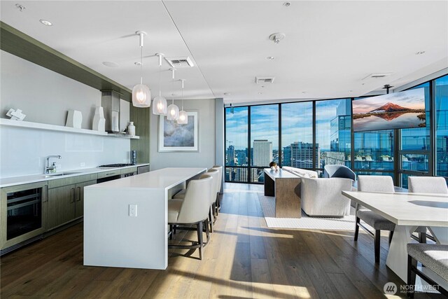 121 Stewart St Unit 2507, Seattle, WA 98101 - kitchen featuring a wall of windows, a sink, dark wood-style floors, light countertops, and open shelves