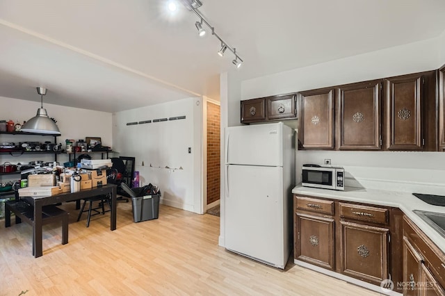 12304 NE 147th Ct, Kirkland, WA 98034 - kitchen featuring freestanding refrigerator, stainless steel microwave, light countertops, dark brown cabinetry, and light wood-style floors