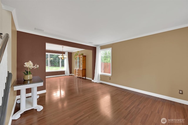 24213 41st Ave E, Spanaway, WA 98387 - empty room featuring crown molding, a chandelier, wood finished floors, and baseboards