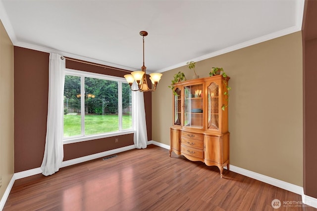 24213 41st Ave E, Spanaway, WA 98387 - unfurnished dining area featuring wood finished floors, a chandelier, baseboards, and ornamental molding