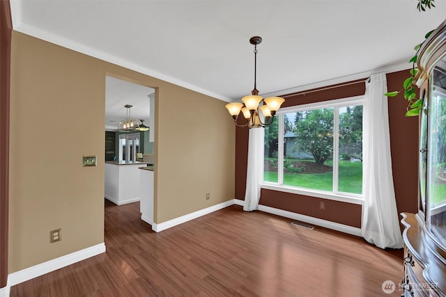 24213 41st Ave E, Spanaway, WA 98387 - unfurnished dining area featuring a chandelier, wood finished floors, baseboards, and crown molding