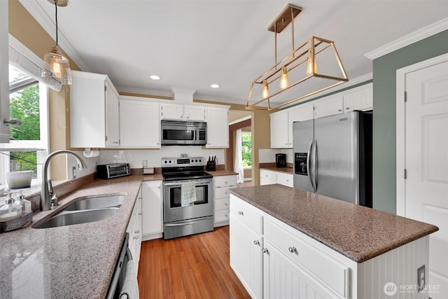 24213 41st Ave E, Spanaway, WA 98387 - kitchen with stainless steel appliances, a sink, crown molding, a center island, and white cabinets